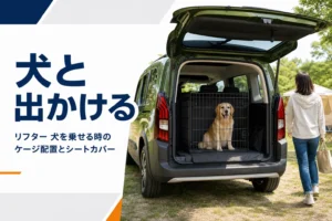 テールゲートを開けた荷室のケージに座る犬